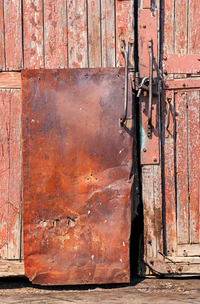 Puerta de madera vieja con revestimiento de hierro —  Fotos de Stock