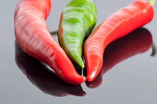 Rood en groen hot chili peppers-achtergrond — Stockfoto