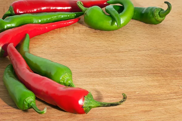 Hot chili peppers op op een houten bord — Stockfoto