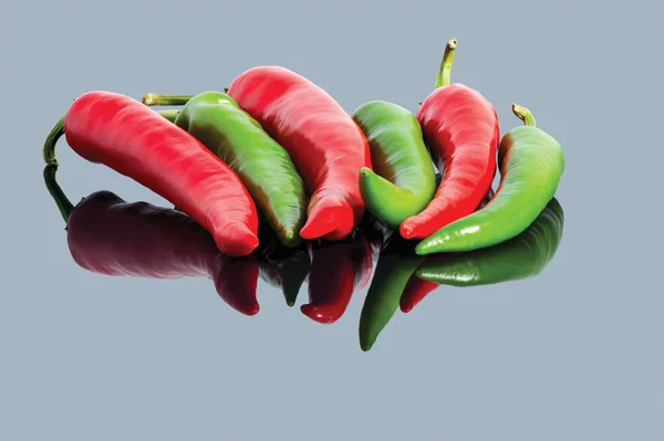 Hot chili papričky červené a zelené pozadí — Stock fotografie
