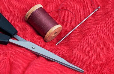 iğne ve iplik kırmızı bir arka plan üzerinde