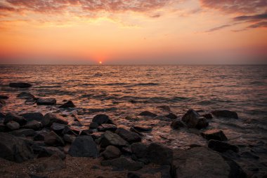 Denizin üzerinde kırmızı mor gün batımı