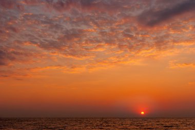 Denizin üzerinde kırmızı mor gün batımı