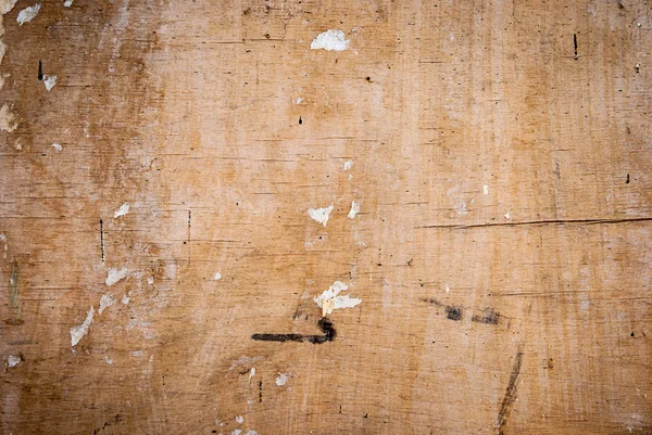 Textura de madera con grietas y los restos del papel viejo —  Fotos de Stock