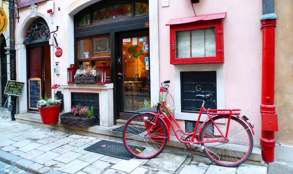 Bicicletta rossa parcheggiata sulla strada — Foto Stock