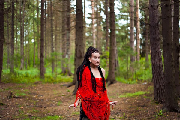 Tight girl with dreadlocks wrapped in a red knitted scarf in a f — Stock Photo, Image