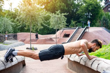 Parktaki temiz havada şınav çeken bir adam..