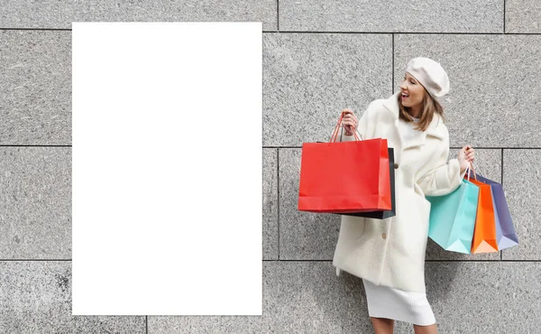 在空白的白色横幅附近放购物袋的妇女 — 图库照片