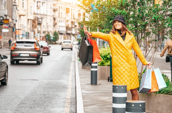 一个带着购物袋的快乐的时尚女人想在街上搭出租车 快乐的生活方式和季节销售 折扣概念 — 图库照片