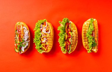 Kırmızı arkaplanda bir Hot Dogs seti.