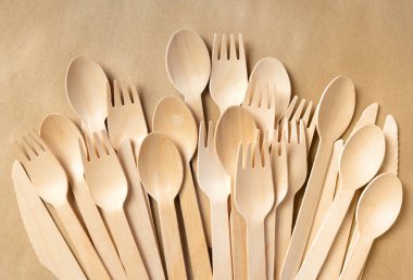 Kağıt üzerine tek kullanımlık tahta çatal bıçak seti. Tahta çatallar, kaşıklar ve bıçaklar yakın plan. Tahta geri dönüşümlü masa ayarları.