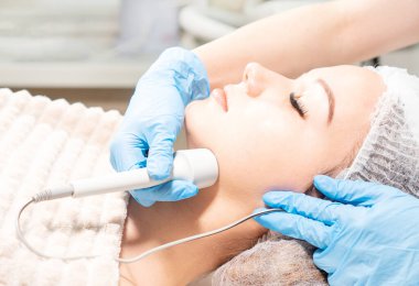 Yüz bakımı için mikro akım terapisi. Kozmetik uzmanı yüz yenileme tedavisi yapıyor..