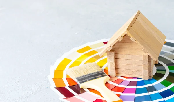 カラーパレットカタログに小さな木造の家とブラシで家や家の改装コンセプトをペイント — ストック写真