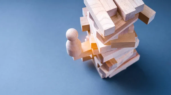 Koncepcja Niepewnej Sytuacji Biznesowej Drewnianą Figurką Człowieka Stojącą Drewnianej Wieży — Zdjęcie stockowe