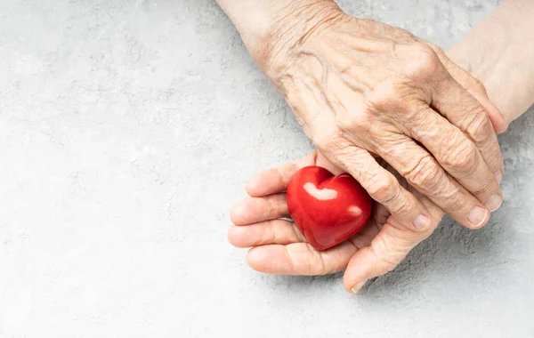 Elderly Heart Health Wrinkled Hands Holding Red Heart Symbol Background — Foto de Stock