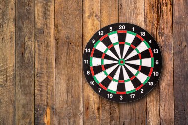 Dart hedefi tahta arkaplanda kopya alanı ile asılı.