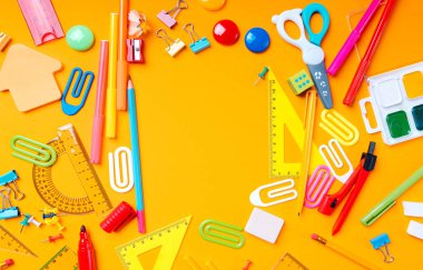 Okula döndüm ve bir fotokopi makinesiyle yatıyordum. Sarı arka planda okul malzemeleri. Üst görünüm.