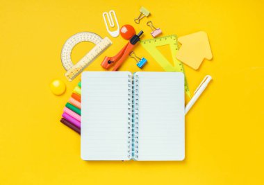 Okul geçmişine dönelim. Boş bir not defteri ve okul malzemeleri. Üst görünüm.