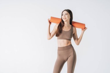 Beautiful asian woman holding fitness mat at the yoga studio. Yoga indoors, fitness training, healthy lifestyle. Copy space.