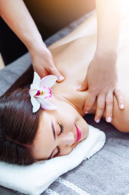 Massage and spa. Relaxing body massage for beautiful asian young woman. Unrecognizible female masseur massaging korean girl's back. Luxury spa, body care, healthy lifestyle. Vertical photography.