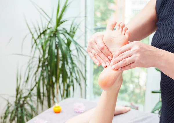 Foot massage at the massage parlor. Female hands massaging the woman\'s feet.