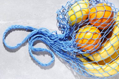 Shopping mesh bag with fruits on the table.