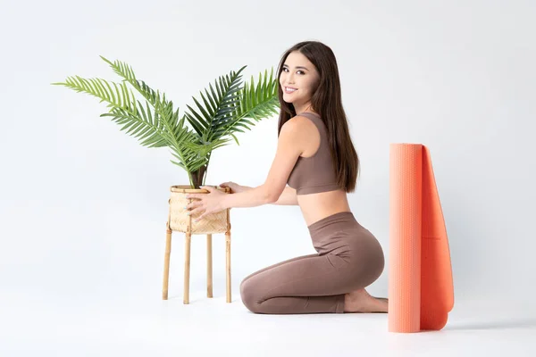 Planning a Fitness or Yoga Studio. Cute asian girl arranging flowers in yoga room.