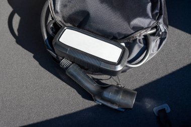 Bir arabanın bagajında duran elektrikli araba şarjı için taşınabilir kablo şarj kutusu..