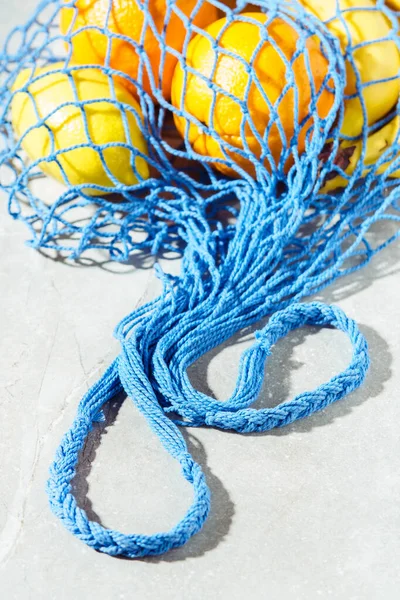 Mesh bag with fruits. Vertical photography.