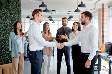 Anlaşmadan sonra el sıkışan iki kendinden emin erkek girişimci, sözleşme yapar