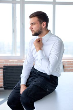 Kendine güvenen işadamı ya da yönetici iş yerinde masasında poz veriyor.