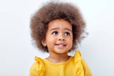 Güzel, kıvırcık saçlı, Afro-Amerikan çocuğunun yakından çekilmiş portresi.