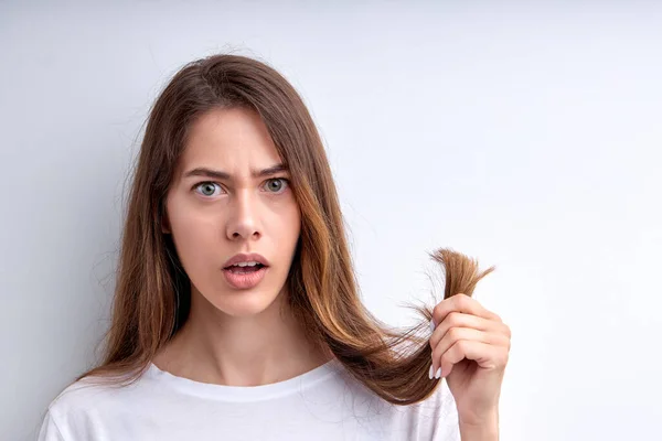 La donna frustrata scossa che tiene capelli in mani, vuole tagliarli fuori, avendo le fini di spacco — Foto Stock