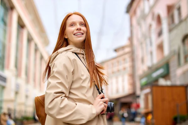 Rödhårig kvinna turist med retrokamera i historiska gamla stan. Gratis avslappnad stil — Stockfoto