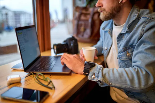 Gesneden succesvolle man zittend in cafe en surfen op internet op laptop. freelance — Stockfoto