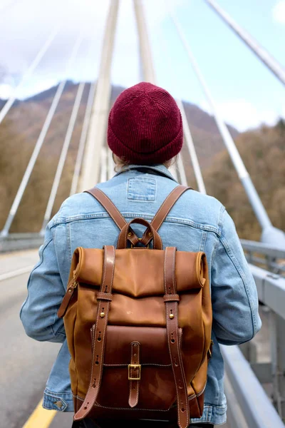 Turist promenader ensam på bron, Resor Livsstil, bakre vy på hane med läder ryggsäck — Stockfoto