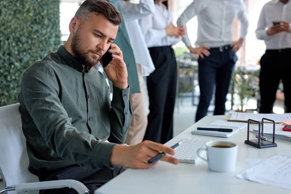 Retrato de empresário confiante falando negócios no telefone no escritório, vista lateral — Fotografia de Stock