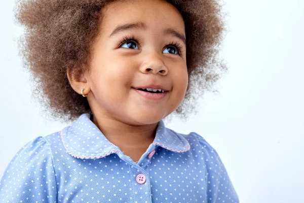 Surpresa menina criança negra em azul t-shirt olhando para cima em algo interessante — Fotografia de Stock