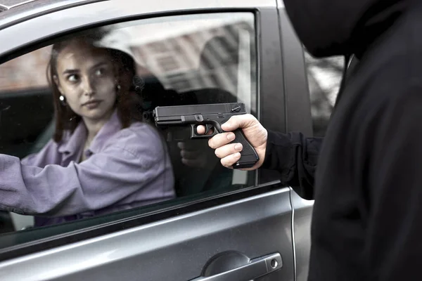 Hooligan ladrón hombre sosteniendo arma de mano gángster para secuestrar rehén mujer conductor coche —  Fotos de Stock