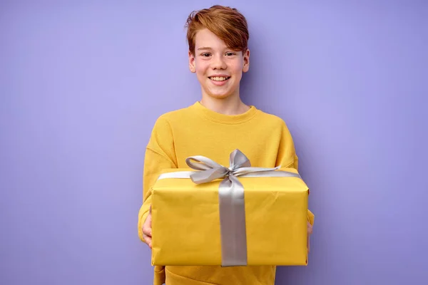 Amüsant glücklich kleiner Junge hält Geschenkbox in den Händen, Kind genießt Geburtstagsgeschenk — Stockfoto