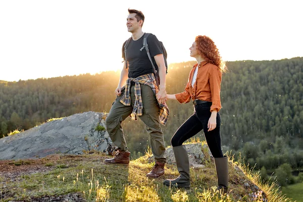Vonzó férfi és nő a hegycsúcsok tetején a természetben, együtt utaznak — Stock Fotó