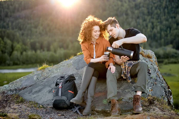 Boldog kaukázusi pár ül, szünetet tartanak, pihennek a hegyekben, teát isznak — Stock Fotó