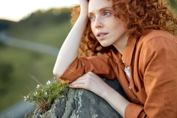 Romantische Frau entspannt sich und legt sich in die Natur. Frau mit roten Haaren ruht. — Stockfoto