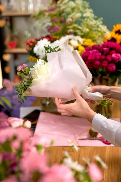 Gente, compras, venta, floristería y concepto de consumismo. cerca de las manos con flores — Foto de Stock