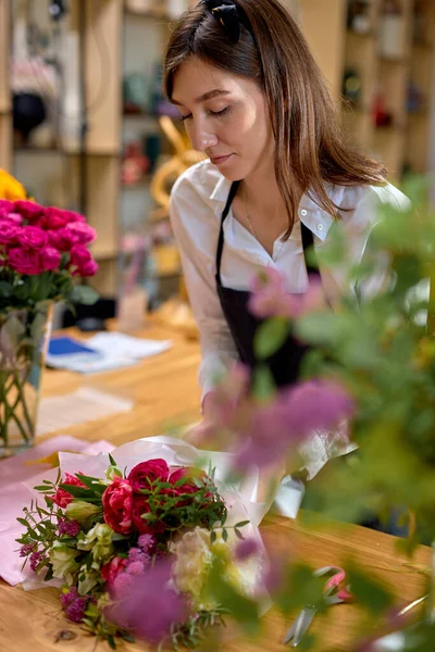 Adorable florista profesional mujer hizo ramo de flores, preparándolas para la venta — Foto de Stock