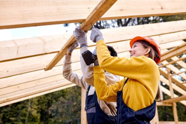 Drill Driver ile çalışan iki heyecanlı müteahhit. Marangoz Ahşap Ev 'de çalışıyor