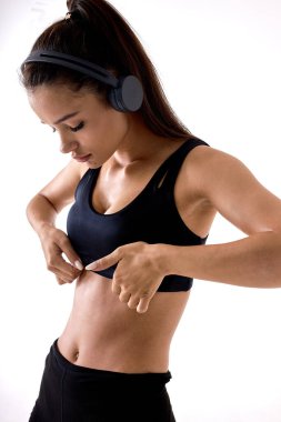 Kendine güveni tam sağlıklı bir kadın spor kıyafetleri içinde kendini soyutlamış bir şekilde aşağıya bakıyor.