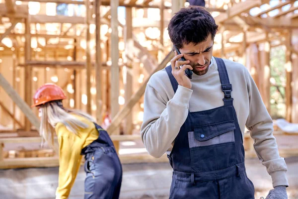 Frustré architecte constructeur homme parler au téléphone contre Nouvelle maison de construction — Photo