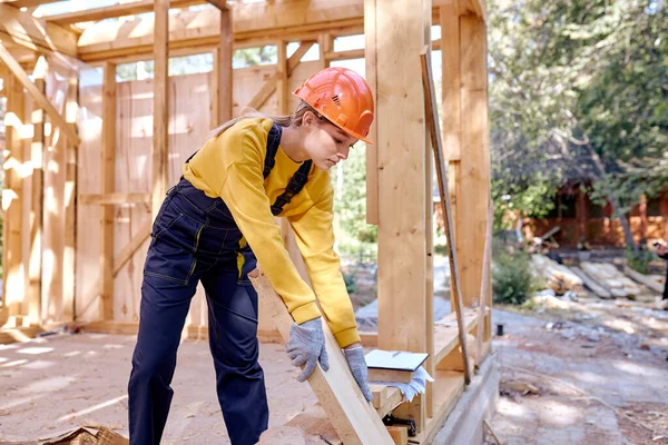 木造建築現場で働く勤勉な女性労働者の制服を着て — ストック写真
