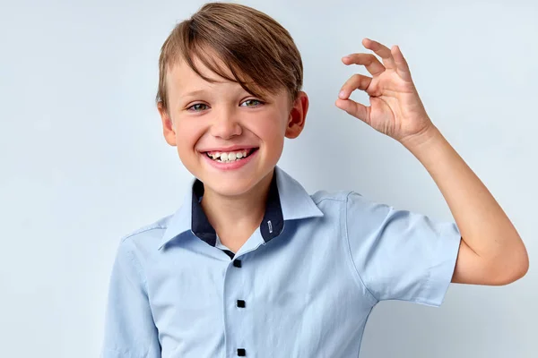 Det är okej. Positiv barn pojke visar ok gest, isolerad på vit studio bakgrund — Stockfoto
